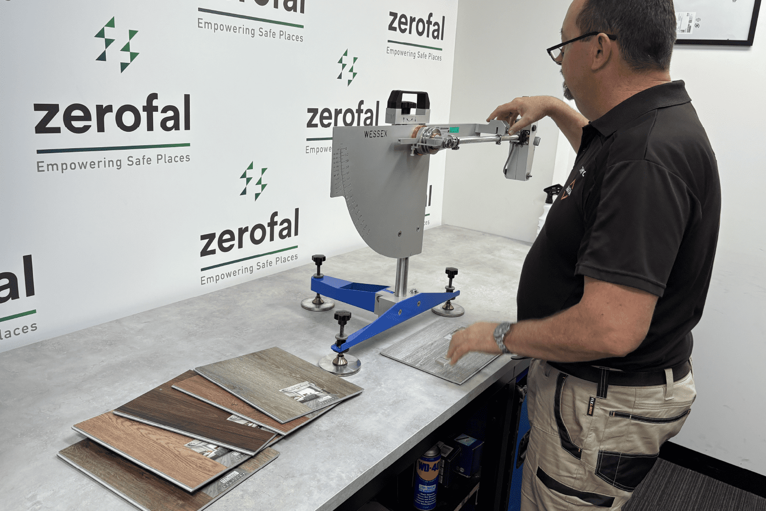 A clean, organised layout of multiple tile samples in different colours and finishes beside a Wessex pendulum tester