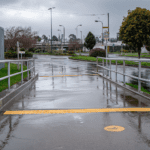 Wet concrete public footpath and access ramp during rainfall showing increased slip risk in municipal setting