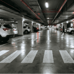 Underground shopping centre car park showing pedestrian crossing and damp floor conditions highlighting slip risk